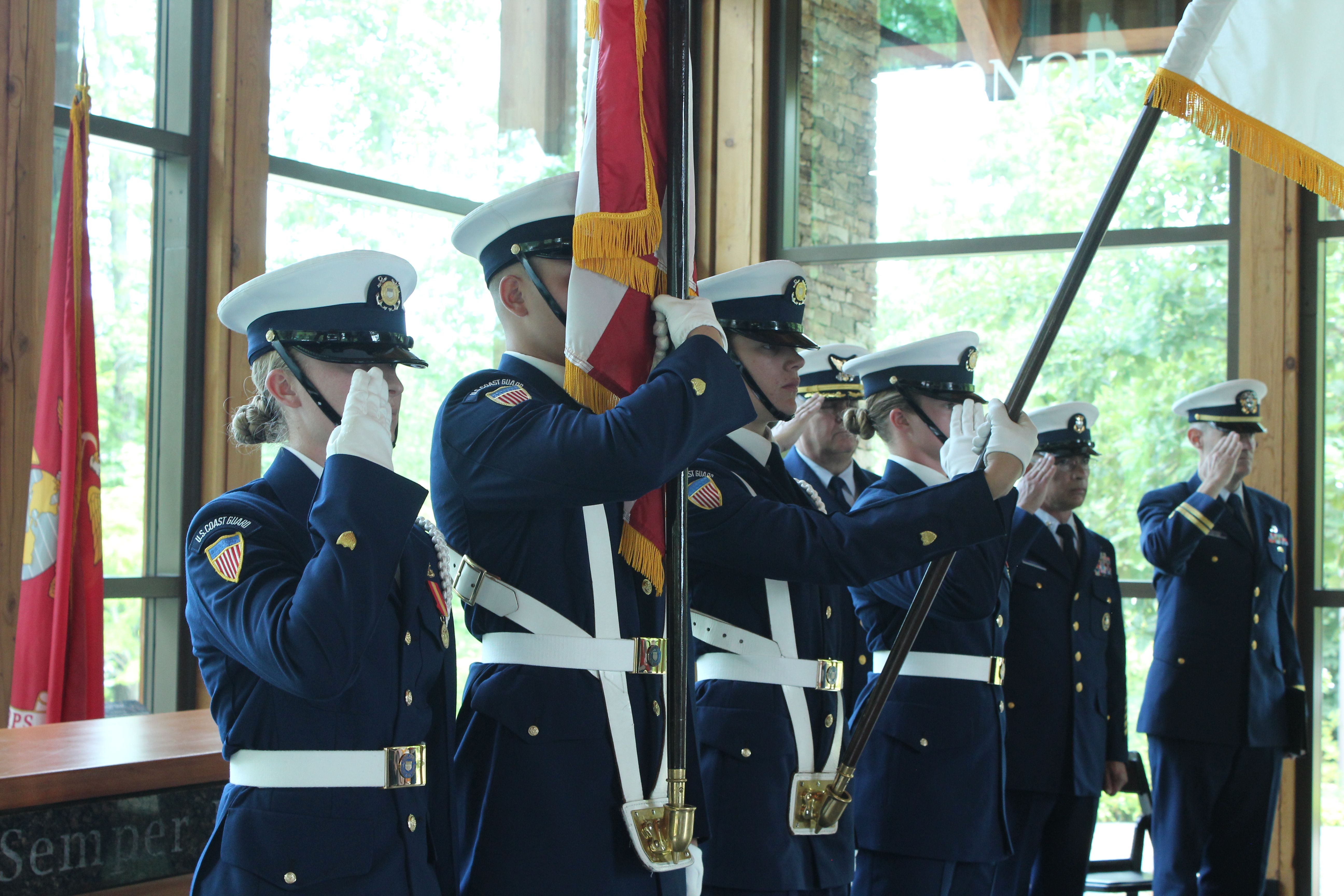 A group of soldiers in uniform holding a flag.
